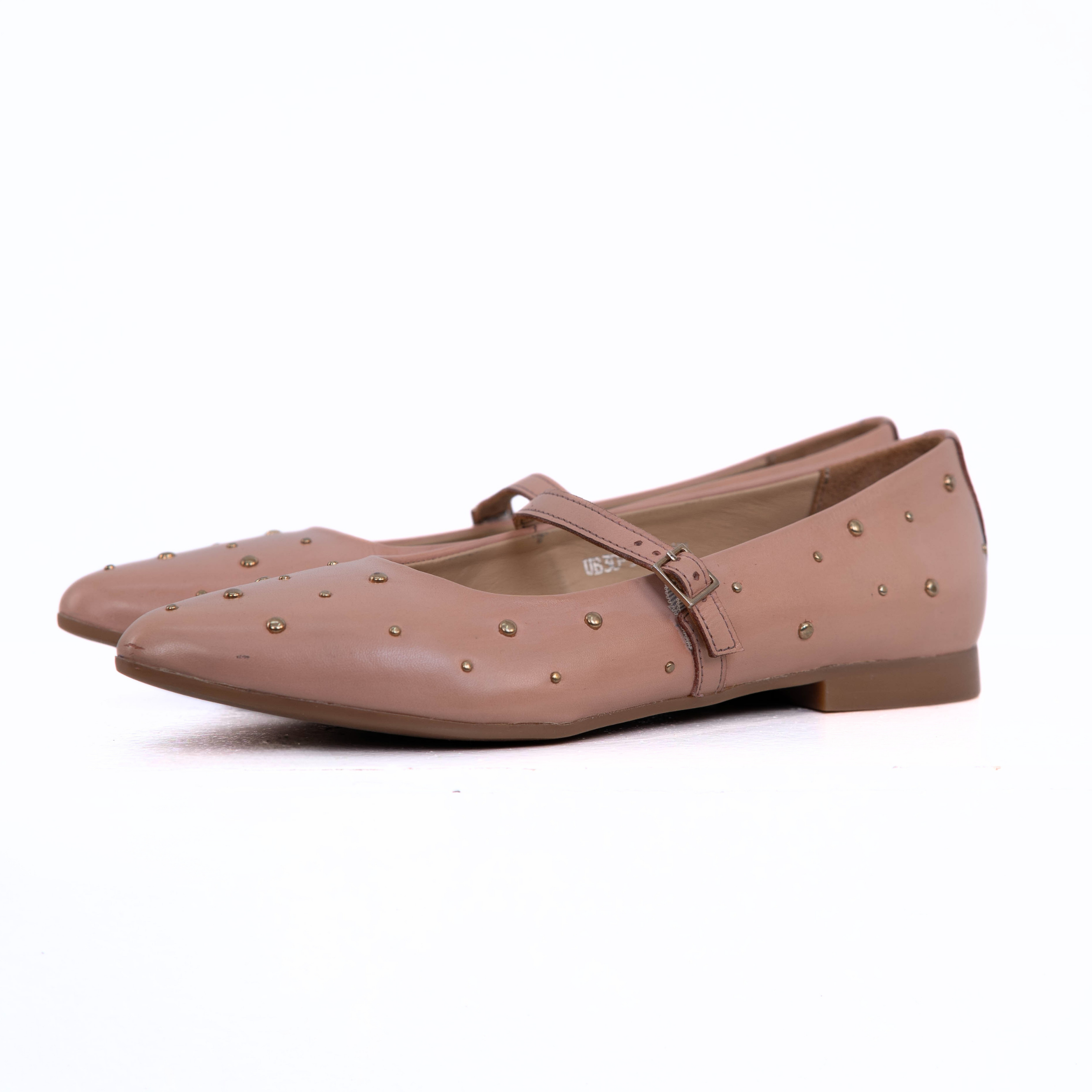 A pair of pointed-toe Mary Jane flats in a dusty rose pink color, decorated with small metallic studs and featuring a low block heel.